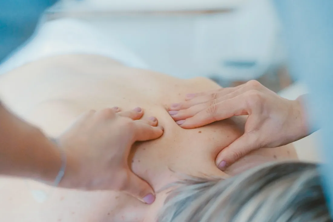 Physiotherapeutin behandelt mit manueller Therapie den Rücken einer Patientin