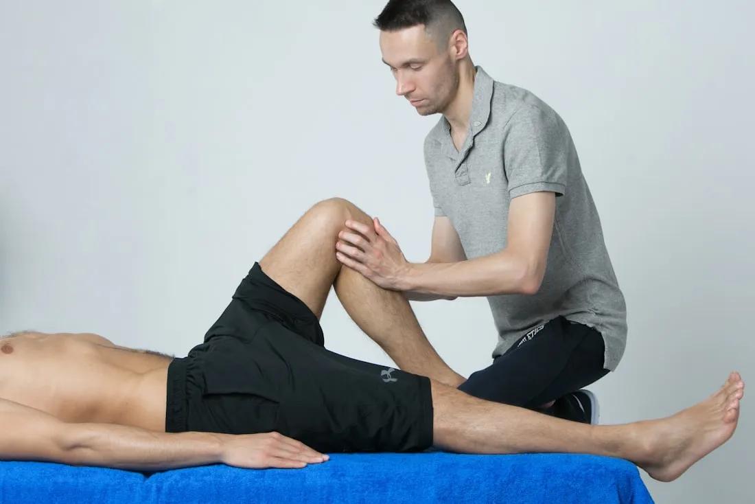Physiotherapeut untersucht und beurteilt das Bein einer Patientin