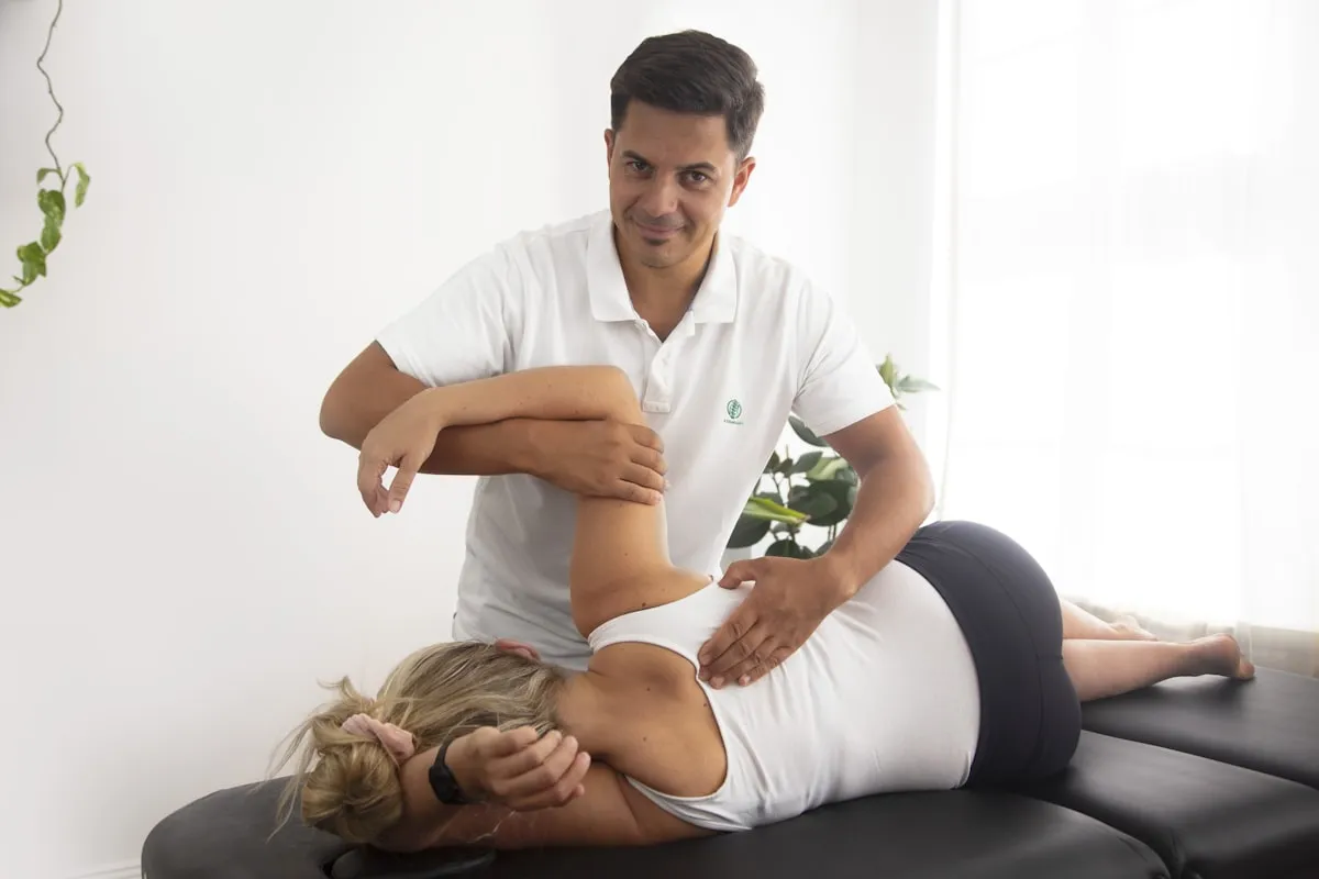 Heller Behandlungsraum mit Therapieliege während einer manuellen Behandlung
